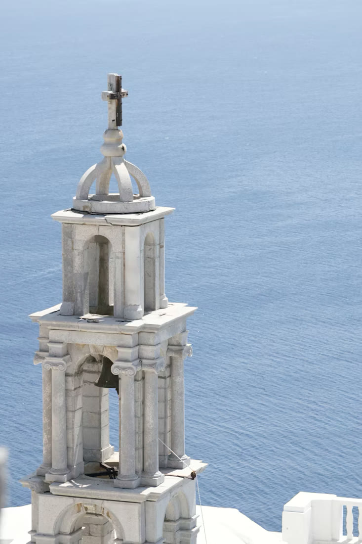 White Cycladic bell tower against the blue sky